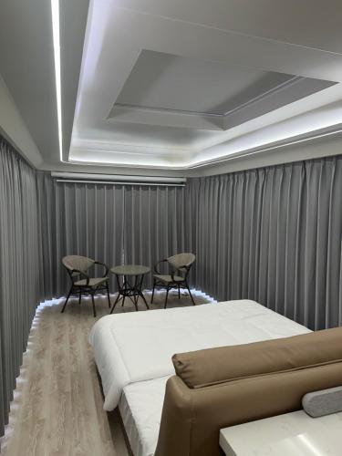 a bedroom with a bed and a table and chairs at Luxury Capsule Haus Phuket in Panwa Beach