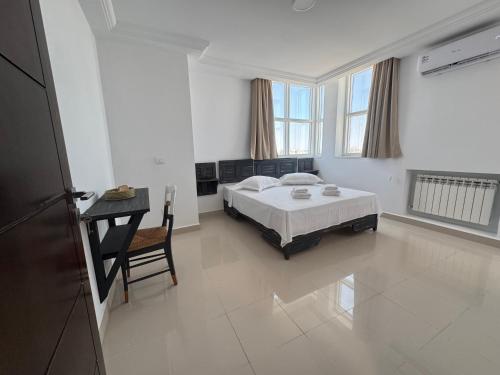 a bedroom with a bed and a desk in it at Le Charbon Mystique in Sfax