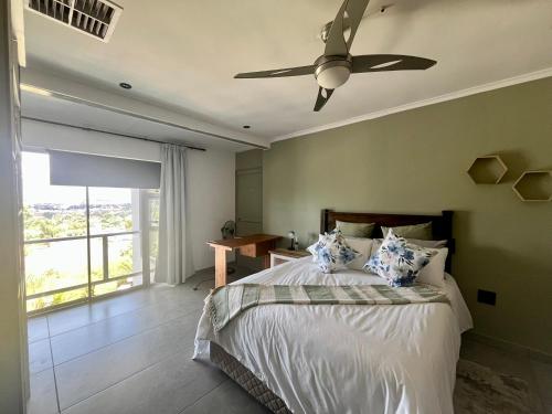 a bedroom with a bed with a ceiling fan at Paarl View House in Paarl
