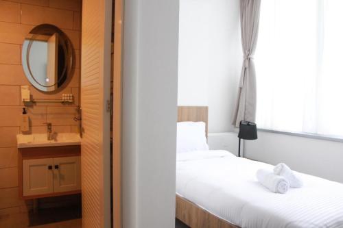 two beds in a room with a sink and a mirror at Hotel Riverside in Skopje