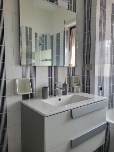a white bathroom with a sink and a mirror at Civico 16 in Perugia