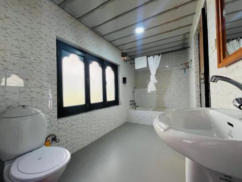 a bathroom with a white toilet and a sink at sinchula Villa Resort in Paro