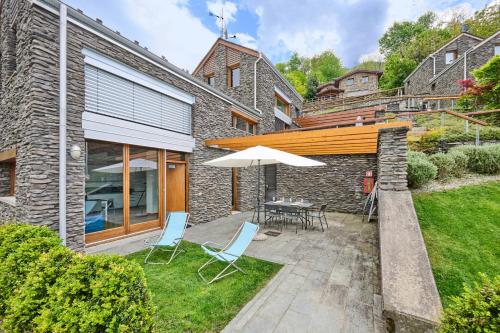 a patio with a table and chairs and an umbrella at house with 3 bedrooms T5 in Bellano