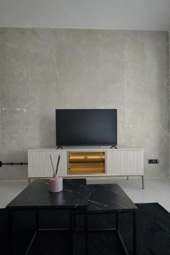 a living room with a tv and a table at Košice Kysucka Apartment in Košice