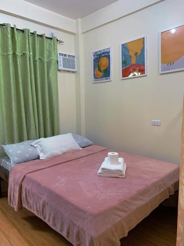 a bedroom with a bed with a green curtain at Cardo Rooms 2 minutes walk from the beach in General Luna