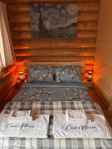 a bed in a log cabin with two lights on it at Casa Alexia in Potoc