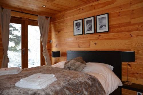 a bedroom with a bed in a log cabin at Boutique Alpine Chalet with Panoramic Views in Thollon