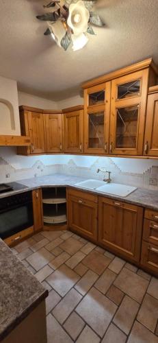 a kitchen with wooden cabinets and a ceiling fan at Ferienwohnung Baumgartner in Aigen im Ennstal