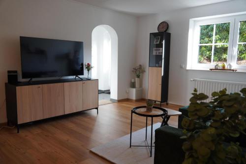 a living room with a flat screen tv on a cabinet at Moor and More Loft in Monschau