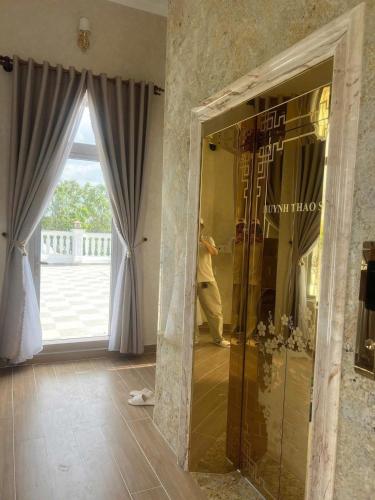 a man taking a picture in a mirror in a room at Huỳnh Thảo in Vũng Liêm
