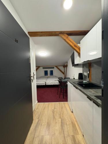 a room with a kitchen and a bedroom with a bed at Apartamenty Stary Młyn in Wronki