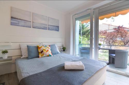 a bedroom with a bed and a large window at Blue Horizon Apartment in Balatonfüred