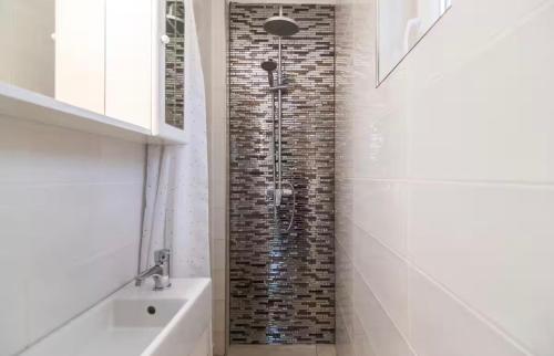 a bathroom with a shower with a brick wall at Blue Horizon Apartment in Balatonfüred