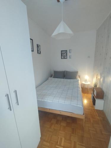 a bedroom with a bed in a white room at Apartman Vuković in Novi Beograd