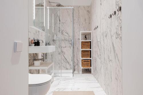 a white bathroom with a toilet and a shower at Luxury Central Riga Studio, Raina Nams in Riga