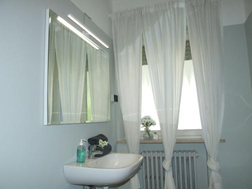 a white bathroom with a sink and a window at Marconi 33A in Pergine Valsugana