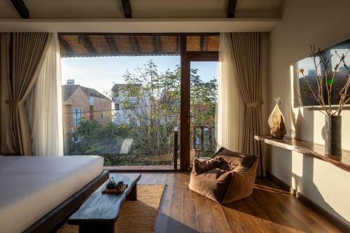 a bedroom with a bed and a large window at ZenHome by M2 in Hoi An