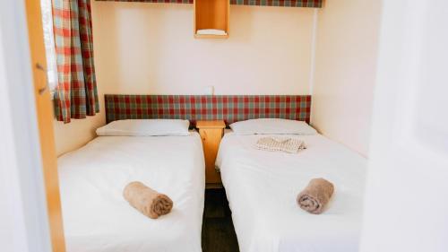 two beds in a small room with towels on them at Nice Camps - L Estartit in L'Estartit