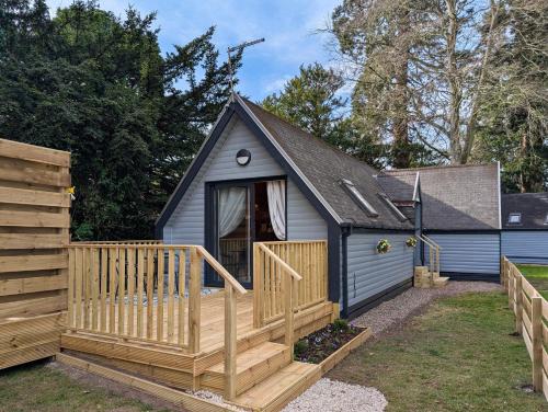 a small shed with a porch and a deck at Cear 2- Private Hot Tub- Perth-Pet Friendly Lodge in Almondbank