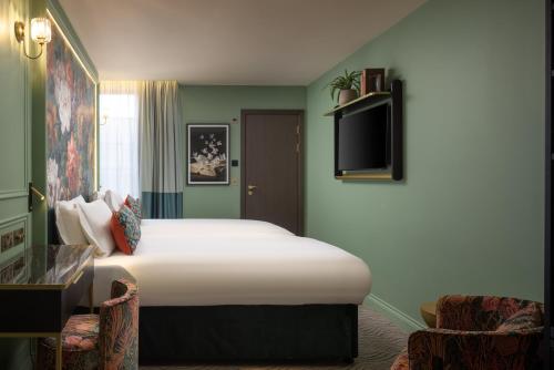 a hotel room with a bed and a tv at The Kensington Hideaway in London