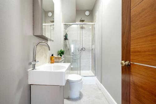 a bathroom with a toilet and a sink and a shower at Sunny Corner Apartment in Center of London in London