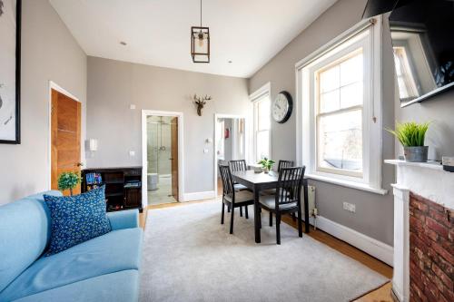 a living room with a blue couch and a table at Sunny Corner Apartment in Center of London in London