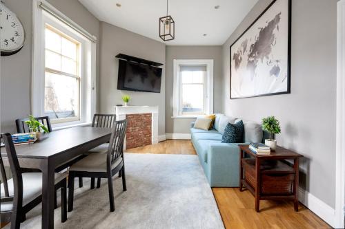 a living room with a blue couch and a table at Sunny Corner Apartment in Center of London in London