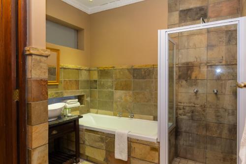 a bathroom with a tub and a sink at Premier Hotel Anta Boga in Bloemfontein