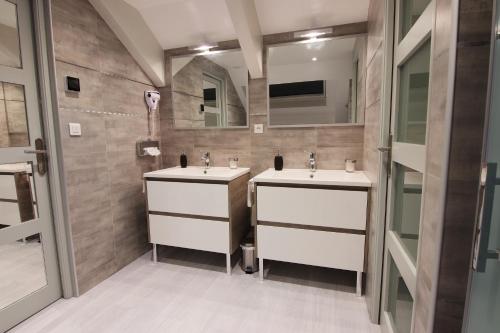 a bathroom with two sinks and a mirror at Le Mas Champenois in Châlons-en-Champagne