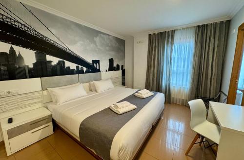 a bedroom with a large bed with a painting on the wall at Hotel Reigosa in Pontevedra