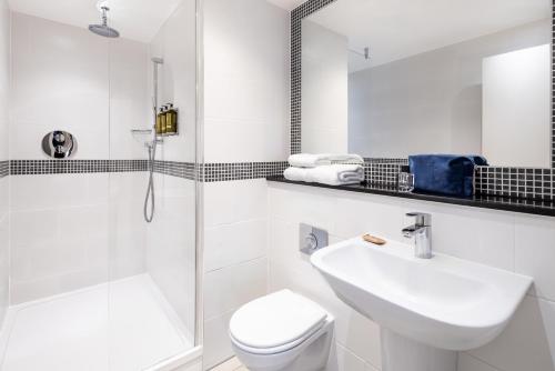a white bathroom with a sink and a toilet at Marlin Waterloo in London