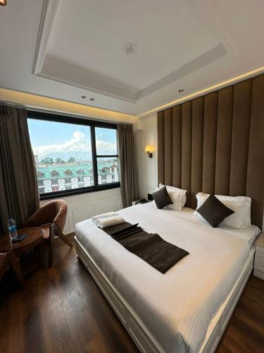 a bedroom with a large bed with a large window at Hotel La Sera in Srinagar