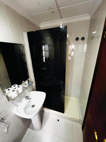 a white bathroom with a sink and a shower at Hostal Cala Verde in Villaricos