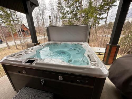 a jacuzzi tub sitting on a patio at Chalet charmant - Détente familiale in Scott