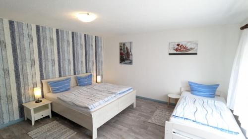 a bedroom with two beds with blue pillows at Nordsee Ferienwohnung Süd in Dornumersiel