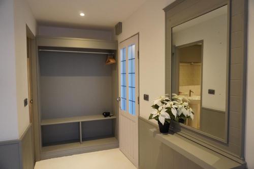 a bathroom with a mirror and a vase with a plant at Residy Hideaway in Patong Beach