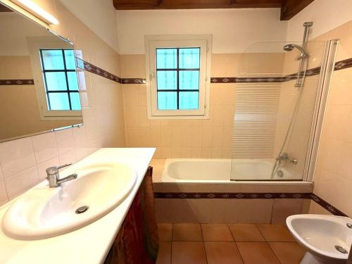 un bagno con lavandino e vasca da bagno di La prairie a Léon