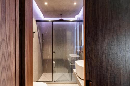 a bathroom with a glass shower with a sink at Selemnos Boutique in Patra