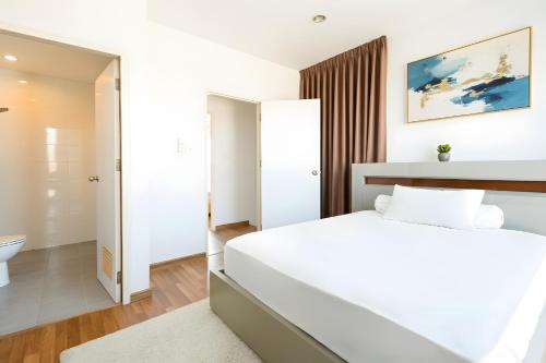 a bedroom with a white bed and a bathroom at Spacious 3BR BKK NEAR 3 Private Bathrooms FAMILY STAY in Min Buri
