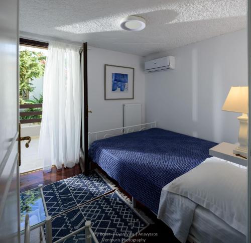 a bedroom with a bed and a window at Cyan Villa in Anavyssos