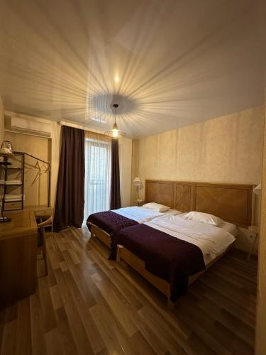 a bedroom with a large bed in a room at Hotel cozy jano in Tbilisi City