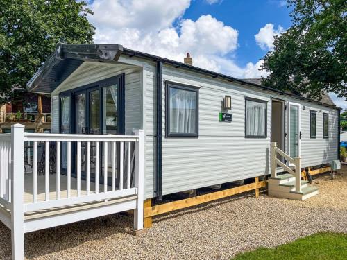 a tiny house with a porch and a fence at Beamish Holiday Park in Stanley