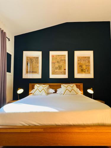 une chambre avec un grand lit avec trois tableaux au mur dans l'établissement Auberge d'Anais, à Vaison-la-Romaine