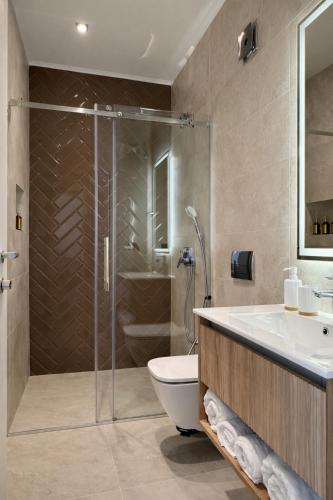 a bathroom with a shower and a toilet and a sink at Giorgio Luxury Suites in Belgrade