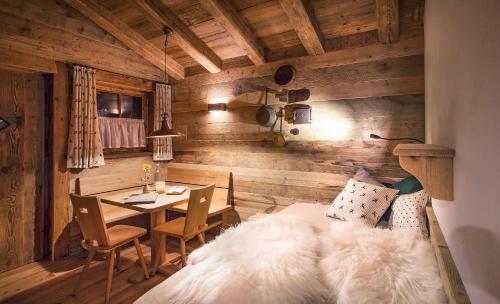 a room with a bed and a table with a dining room at Alpin Chalets Oberjoch in Bad Hindelang