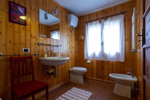 a bathroom with a sink and a toilet and a window at Orme nel parco - Villaggio Grechi in Tirivolo