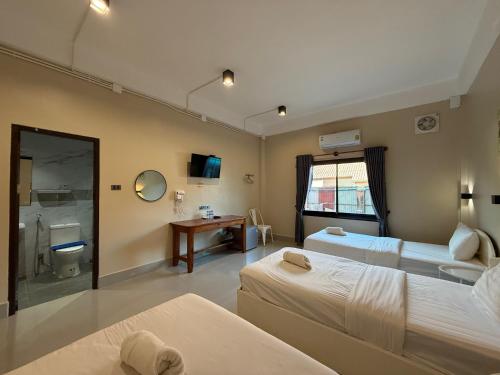 una camera d'albergo con due letti e un bagno di Phaythavone Hotel a Pakse