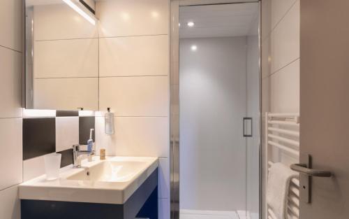 a bathroom with a sink and a mirror at Logis Hotel Restaurant Au Chêne Vert, Saint-Brieuc in Plérin