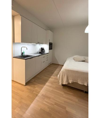 a kitchen with a sink and a bed in a room at LuxHOMES Studio in Tapiola in Espoo