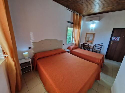 a hotel room with two beds and a table at Casolare Al Porto in Tropea